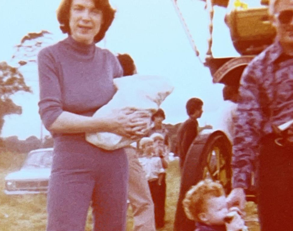 Vintage photo of a family outdoors with a tractor in the background